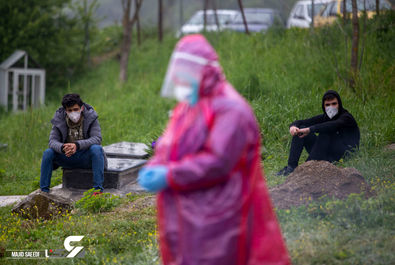 فرزندان یک قربانی کووید-19 در مراسم تشییع پیکر پدرشان طبق پروتکل‌های بهداشتی با فاصله ایستاده‌اند ، روستای اسکارد - مازندران